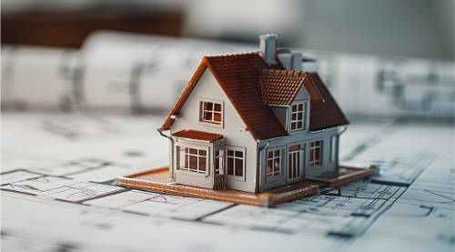 Small model house on top of blueprints